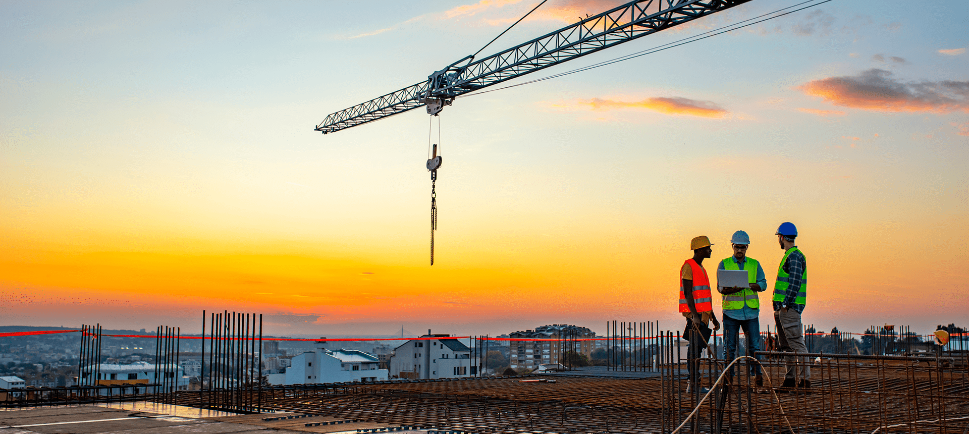 Construction workers at sunset with crane